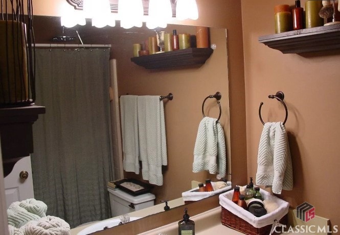 bathroom with a shower with curtain and toilet