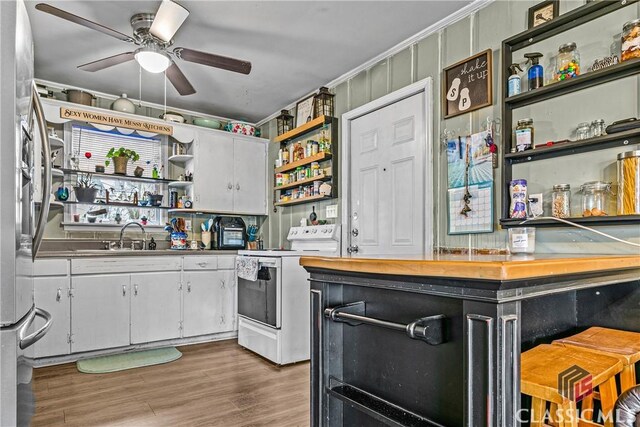 kitchen featuring white cabinets, dark hardwood / wood-style floors, sink, and white stove