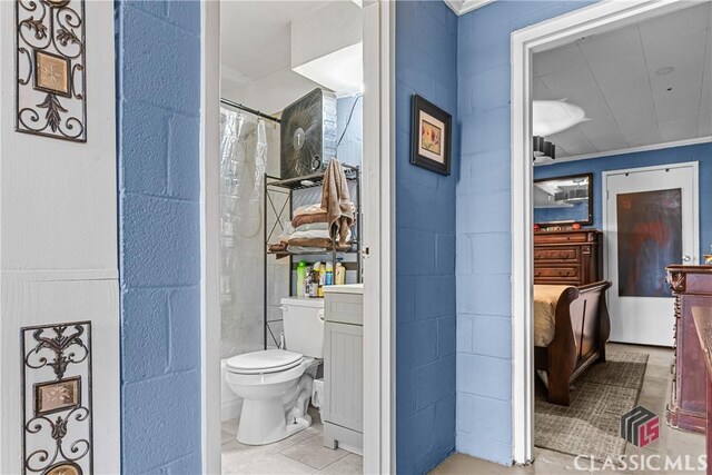 bathroom featuring toilet, ornamental molding, and walk in shower