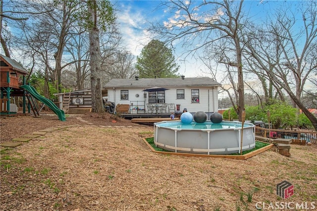 back of property with a pool side deck and a playground