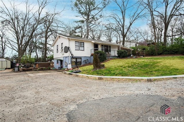 view of front facade with a front lawn, covered porch, and a storage unit