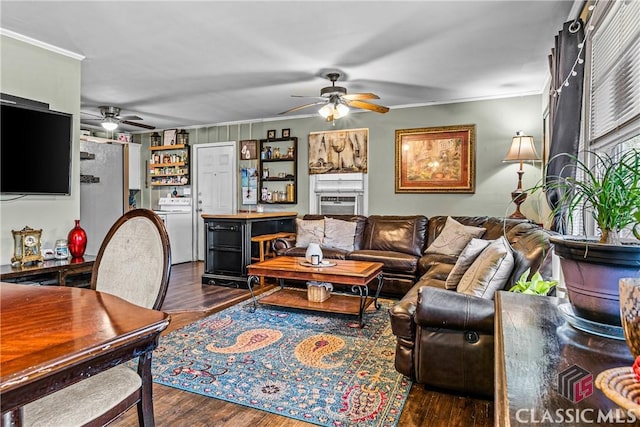 living room with ceiling fan, dark hardwood / wood-style flooring, crown molding, and washer / clothes dryer
