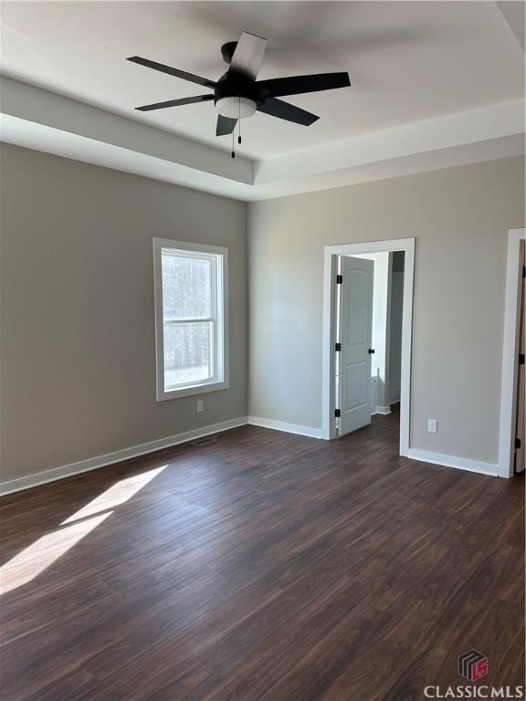 empty room with dark wood-type flooring and ceiling fan