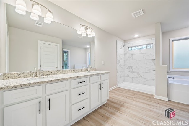 bathroom with hardwood / wood-style floors, vanity, and independent shower and bath