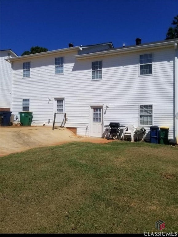 back of house with a yard and a patio