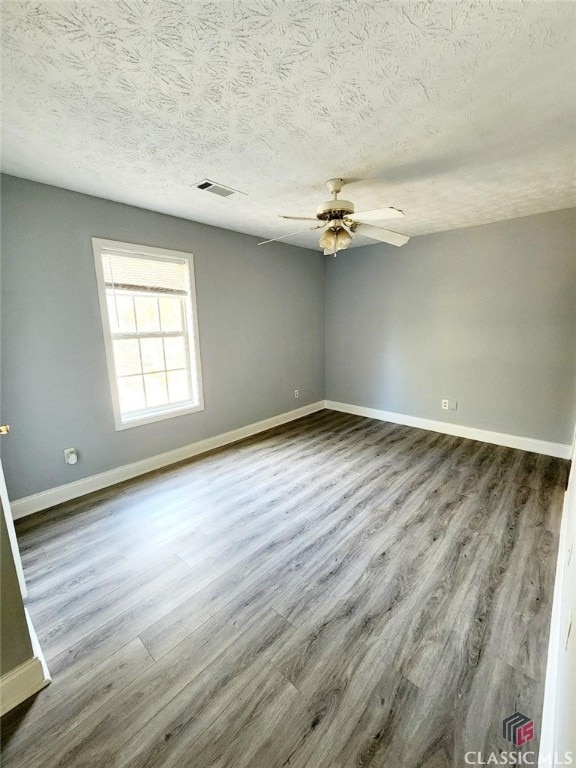 spare room featuring wood-type flooring, a textured ceiling, and ceiling fan