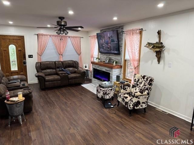 living room featuring a fireplace, dark hardwood / wood-style floors, and ceiling fan