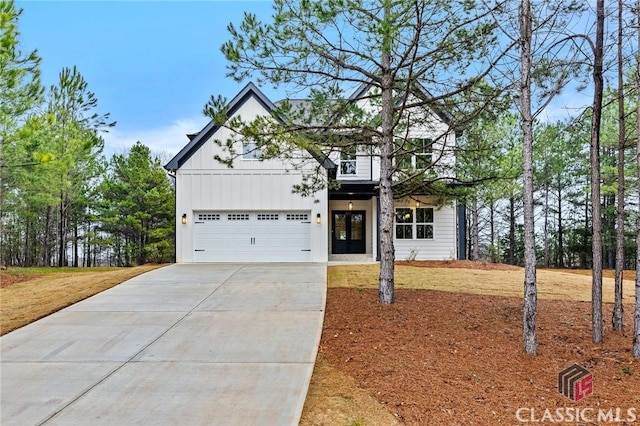 modern inspired farmhouse featuring a garage, board and batten siding, and concrete driveway