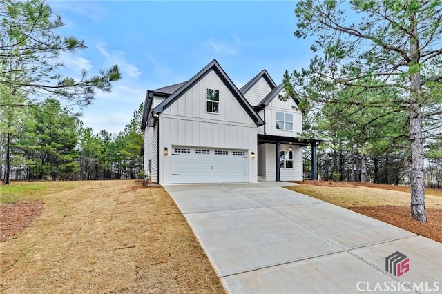 modern inspired farmhouse featuring driveway, an attached garage, board and batten siding, and a front yard