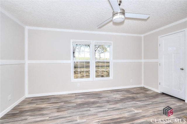 empty room with ceiling fan, crown molding, a textured ceiling, and hardwood / wood-style flooring