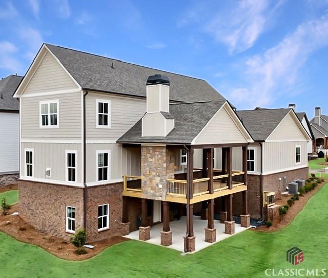 1745 Silo Bnd Unit 16, Watkinsville, GA 30677 - rear view of house featuring roof with shingles, central AC unit, a chimney, a yard, and a patio area