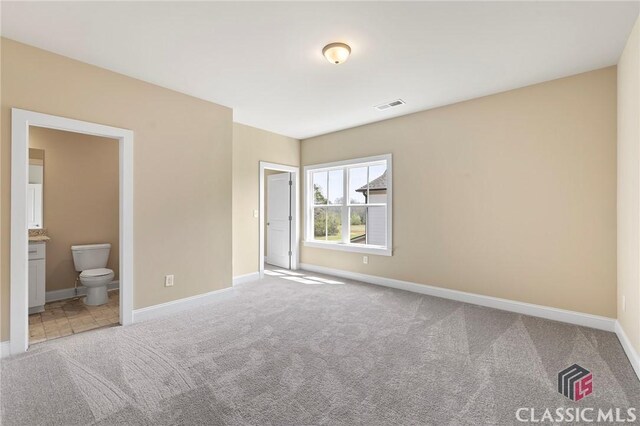 1745 Silo Bnd Unit 16, Watkinsville, GA 30677 - unfurnished bedroom featuring visible vents, connected bathroom, baseboards, and carpet floors