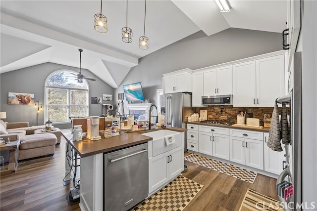 kitchen with backsplash, a center island with sink, white cabinets, and appliances with stainless steel finishes