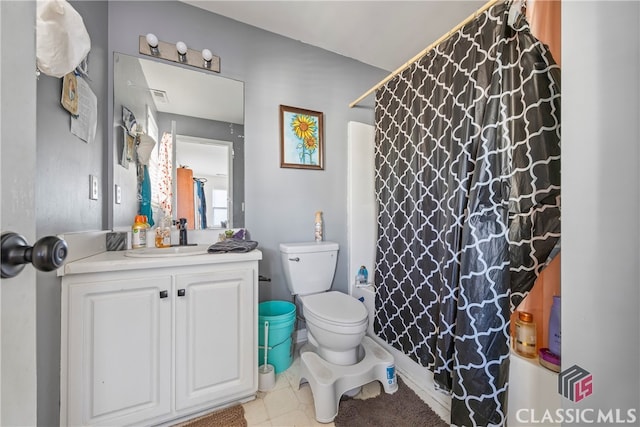 bathroom with tile patterned floors, vanity, toilet, and walk in shower