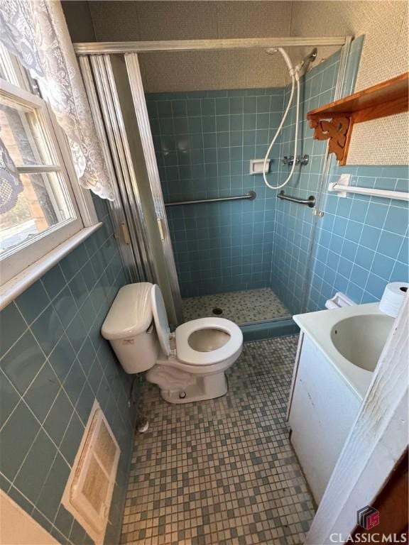 bathroom featuring tile patterned floors, toilet, a tile shower, and vanity