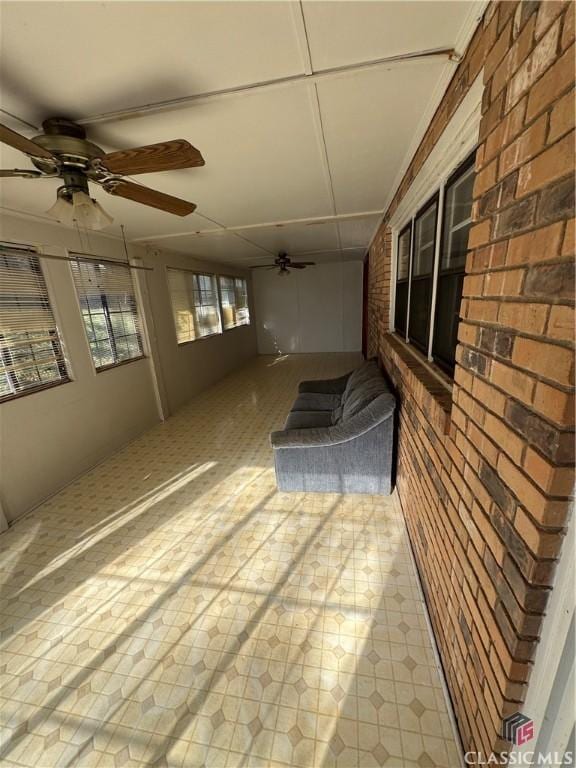 unfurnished sunroom with ceiling fan