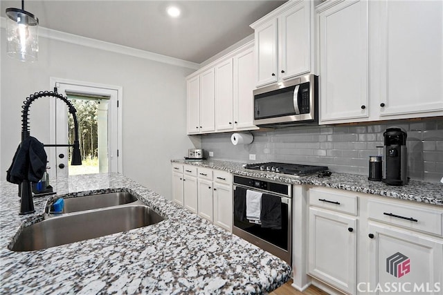 kitchen featuring white cabinets, sink, tasteful backsplash, decorative light fixtures, and stainless steel appliances