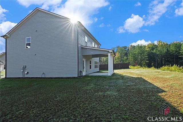 view of side of property with a lawn and a patio area