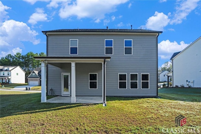 rear view of property featuring a lawn and a patio area