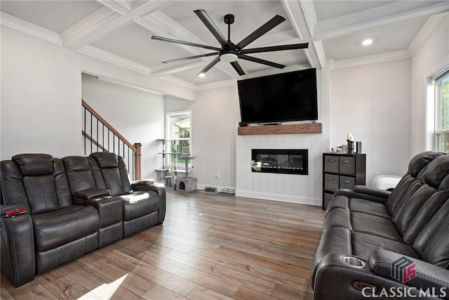 living room with a large fireplace, coffered ceiling, and hardwood / wood-style flooring