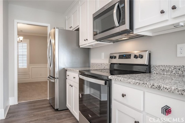 kitchen featuring crown molding, white cabinets, and stainless steel appliances