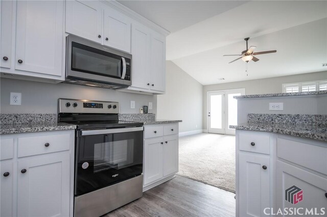 kitchen with white cabinetry, ceiling fan, stainless steel appliances, and light stone counters