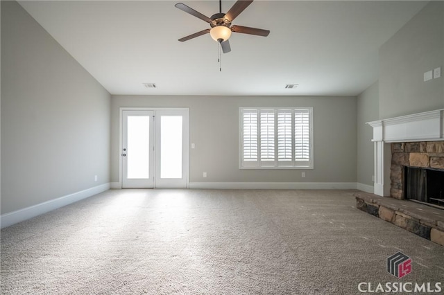 unfurnished living room featuring ceiling fan, a fireplace, and light colored carpet