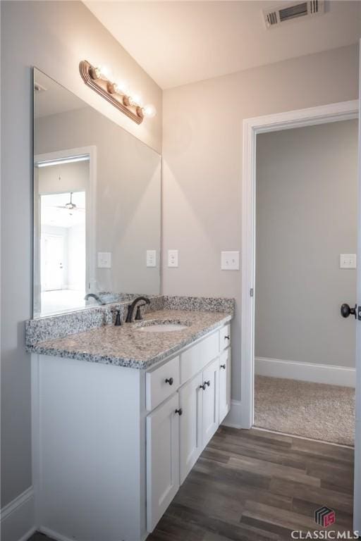 bathroom featuring ceiling fan, hardwood / wood-style floors, and vanity