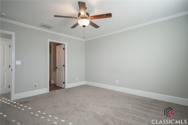 spare room featuring carpet, ceiling fan, and crown molding