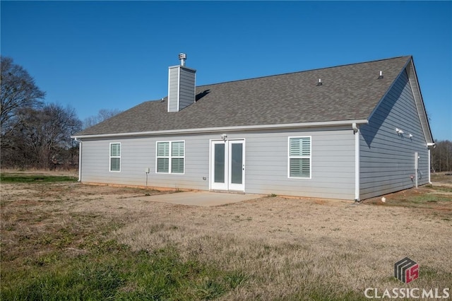 back of house with a lawn and a patio