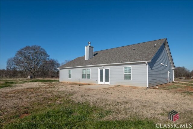 rear view of property with a patio and a lawn