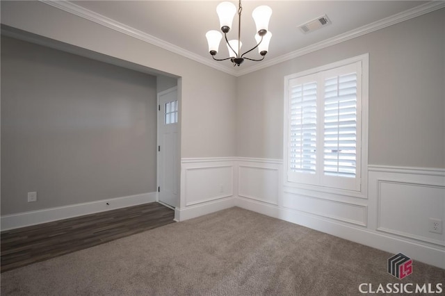 unfurnished room featuring dark carpet, ornamental molding, and an inviting chandelier