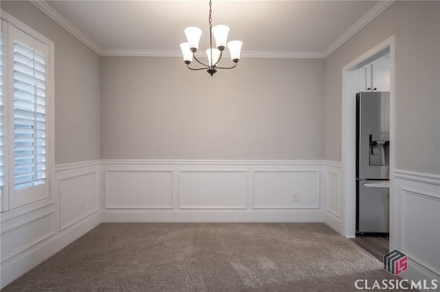 carpeted empty room with a notable chandelier and crown molding