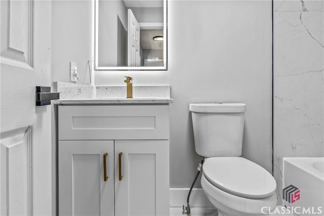 bathroom featuring vanity, toilet, and a shower