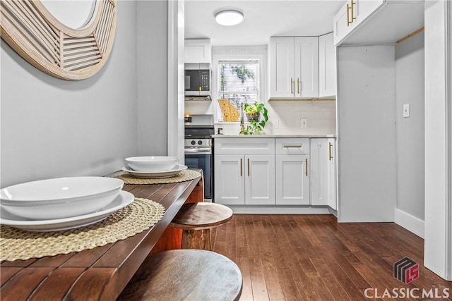 kitchen with backsplash, stove, white cabinets, and dark wood-type flooring