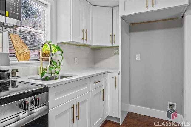 kitchen with decorative backsplash, light stone counters, white cabinetry, and sink