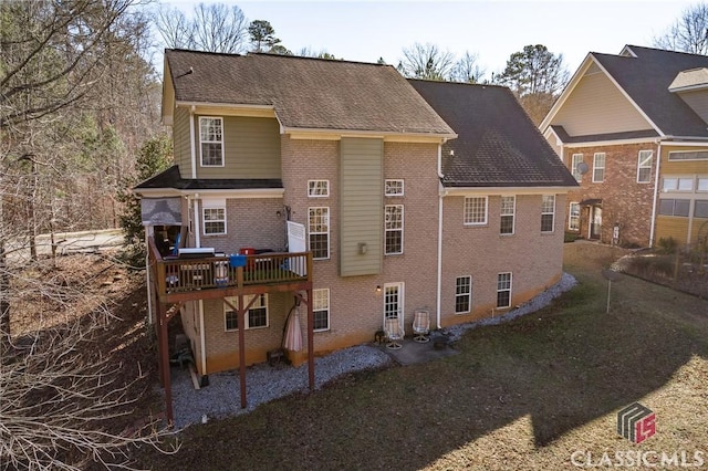 rear view of property featuring a deck and a yard