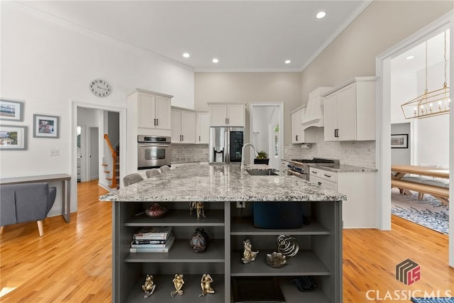 kitchen with a large island, light stone countertops, stainless steel appliances, tasteful backsplash, and custom range hood