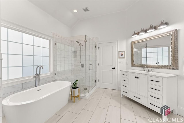 bathroom with tile patterned floors, plenty of natural light, and vaulted ceiling