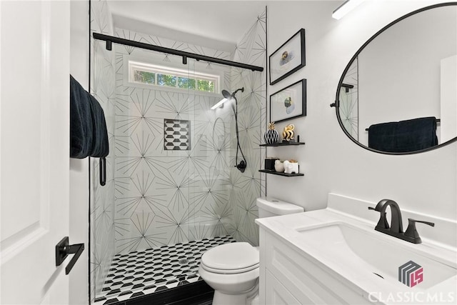 bathroom featuring a shower with door, vanity, and toilet