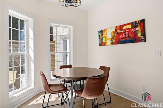 dining room featuring plenty of natural light, an inviting chandelier, and hardwood / wood-style flooring