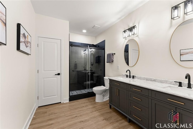 bathroom with vanity, hardwood / wood-style flooring, toilet, and an enclosed shower