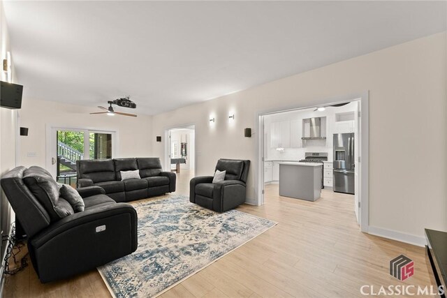 living room with light hardwood / wood-style flooring and ceiling fan