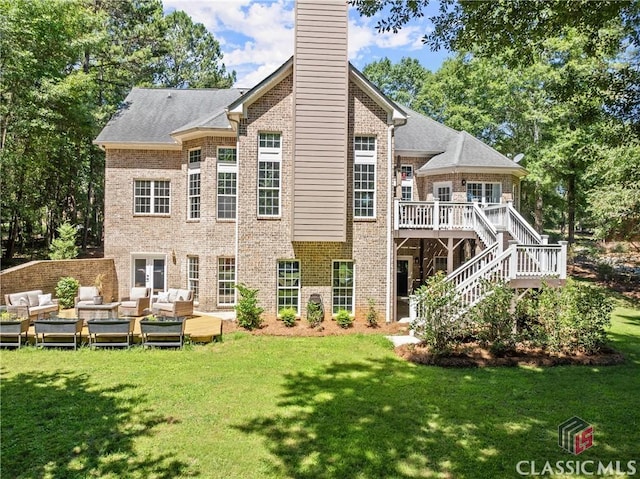 back of property featuring a lawn, a wooden deck, and an outdoor living space