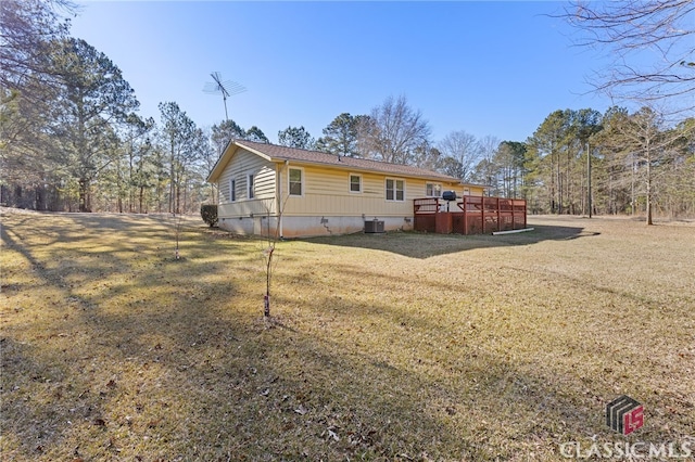 rear view of house with a deck, a yard, and central air condition unit