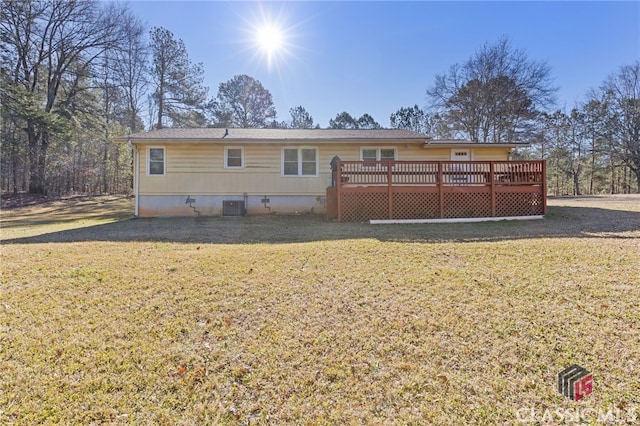 rear view of property with a deck, cooling unit, and a lawn