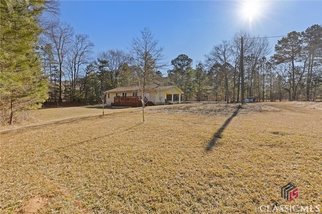 view of front facade featuring a deck and a front lawn