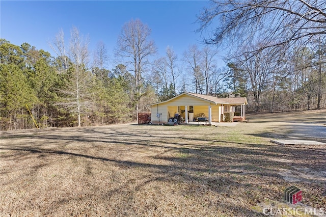 view of side of property featuring a lawn and a porch