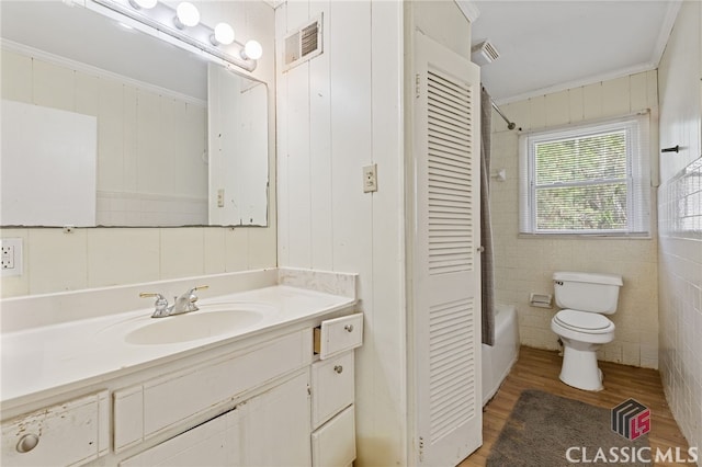 full bathroom featuring shower / bathtub combination, ornamental molding, vanity, hardwood / wood-style floors, and toilet