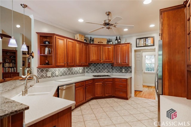 kitchen featuring kitchen peninsula, appliances with stainless steel finishes, crown molding, sink, and pendant lighting